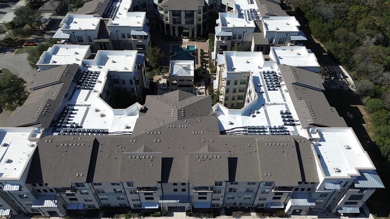 Aerial view of a San Antonio multi-building apartment property with low slope membrane and steep slope shingle roofs