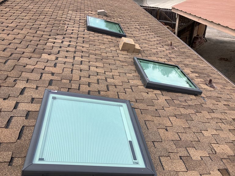 Three skylights, vent stacks and pipe boots on a San Antonio asphalt shingle roof, flashing rebuilt by BH Roofing